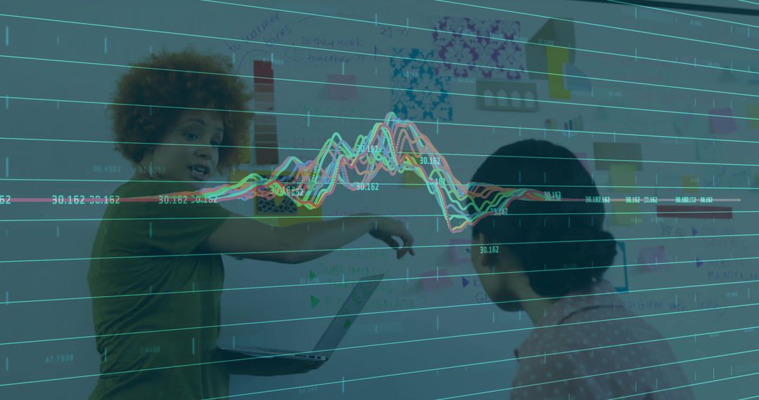 Women collaborating at whiteboard with colorful data visualization overlay for teamwork