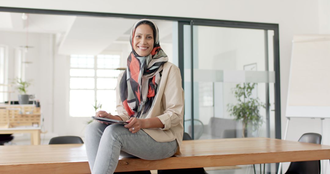 Confident Professional Woman in Hijab Smiling at Camera in Office - Free Images, Stock Photos and Pictures on Pikwizard.com