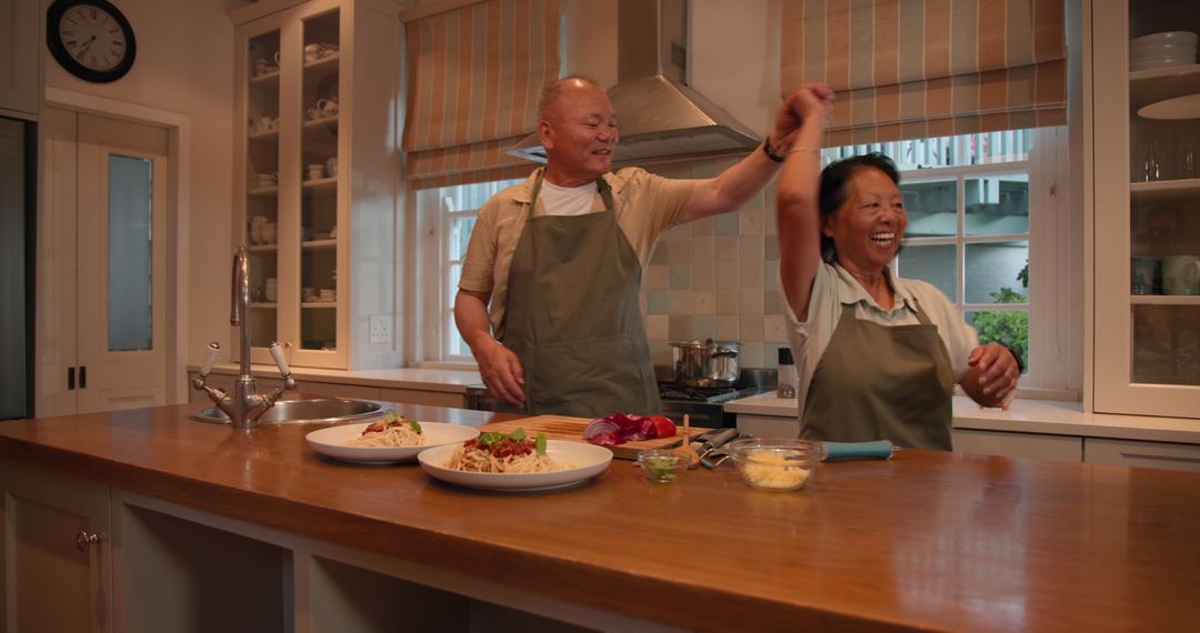 Senior Asian Couple Enjoying Cooking Together in Cozy Home Kitchen