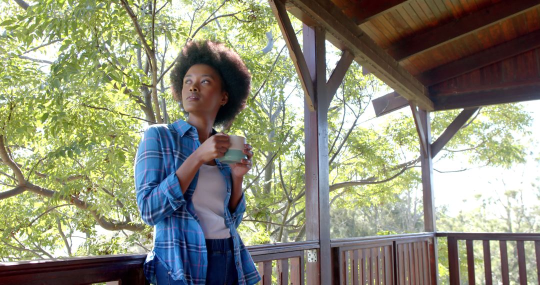 Young Woman Drinking Coffee on Balcony Amidst Nature - Free Images, Stock Photos and Pictures on Pikwizard.com