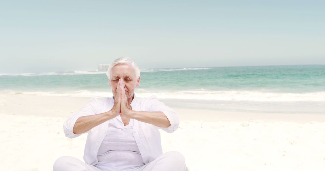 Senior Woman Meditating on Beach in White Clothing - Free Images, Stock Photos and Pictures on Pikwizard.com