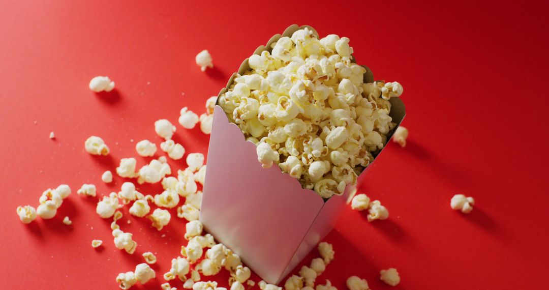 Box of Popcorn on Bright Red Surface with Scattered Kernels - Free Images, Stock Photos and Pictures on Pikwizard.com