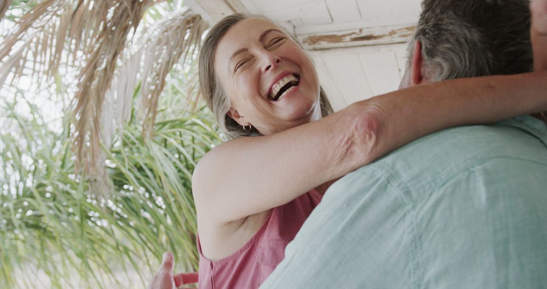 Happy Senior Couple Hugging Outdoors in Tropical Setting - Free Images, Stock Photos and Pictures on Pikwizard.com