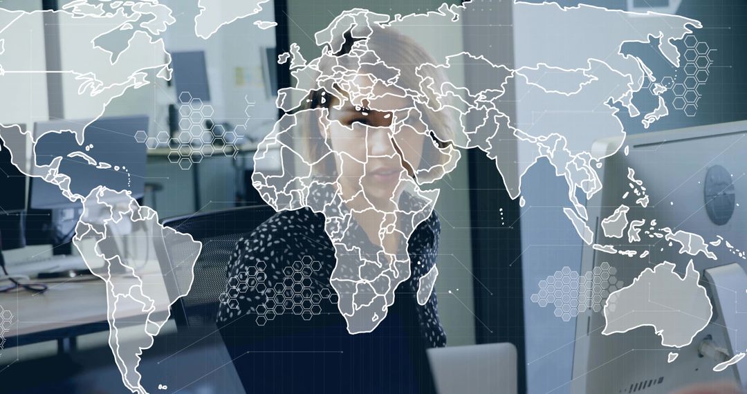 Analyst in Office with Digital World Map Overlay on Screen