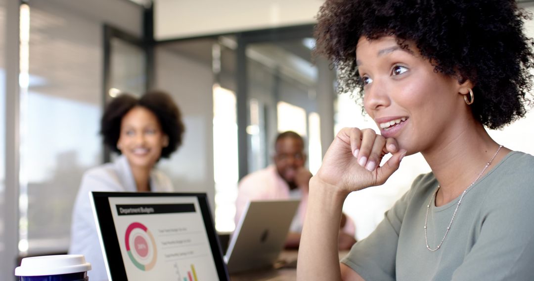 Diverse Team Analyzing Business Chart on Laptop in Modern Office