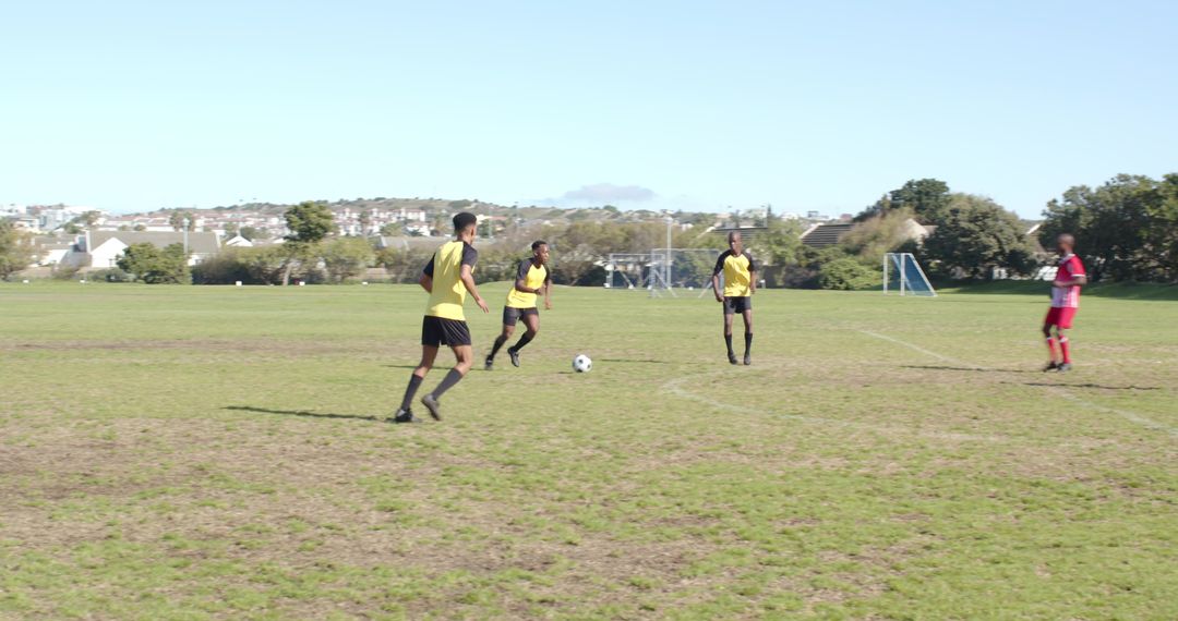Soccer Team Practicing on Pitch with Clear Skies