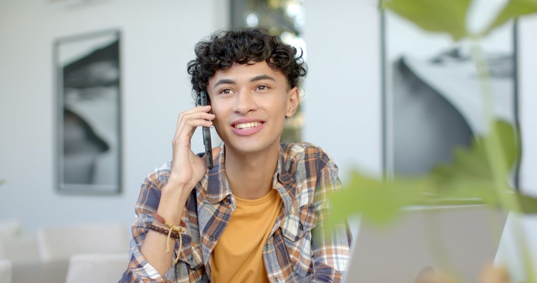 Young Man Communicating via Smartphone in Home Office Environment