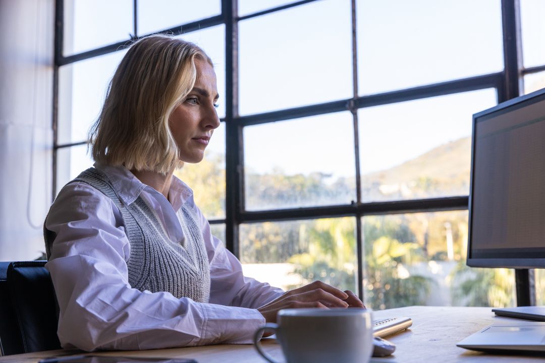 Professional Woman Working at Modern Office Desk with Monitor