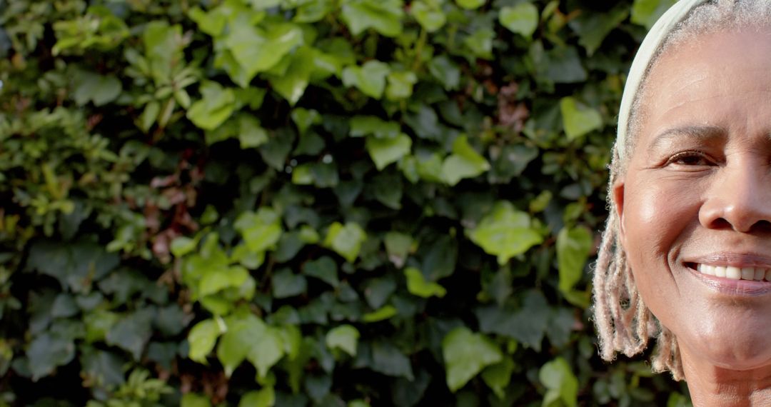 Smiling Elderly Woman with Dreadlocks Against Ivy Background - Free Images, Stock Photos and Pictures on Pikwizard.com