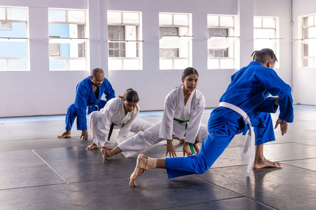Martial Artists Practicing Stretches in a Sunlit Dojo