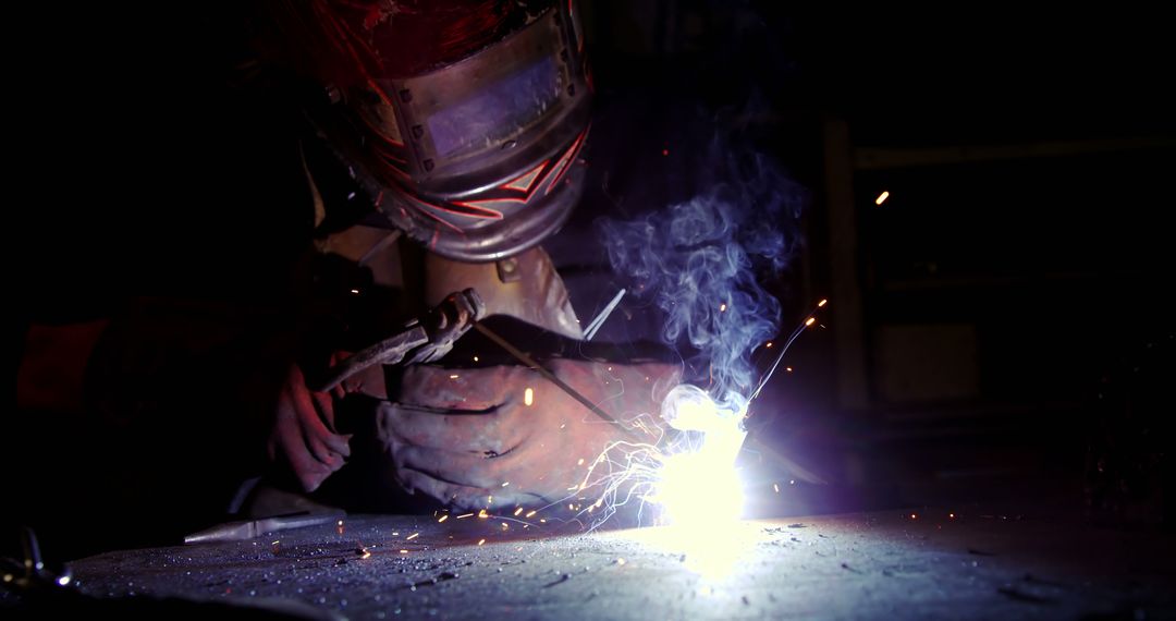 Industrial Welder Wearing Helmet Working with Sparks and Smoke - Free Images, Stock Photos and Pictures on Pikwizard.com