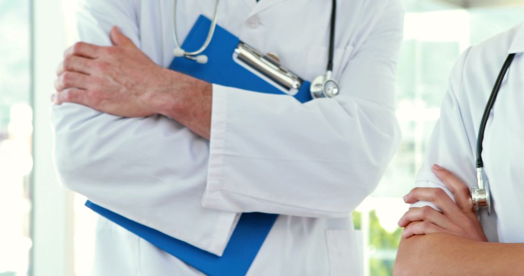 Two Doctors Standing Arms Crossed in Hospital - Free Images, Stock Photos and Pictures on Pikwizard.com