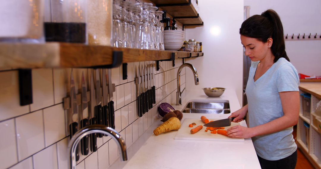 Young Woman Preparing Fresh Carrots in Modern Kitchen - Free Images, Stock Photos and Pictures on Pikwizard.com