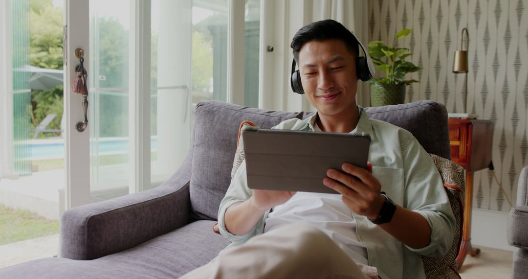 Relaxed Man Enjoying Digital Content on Tablet at Home