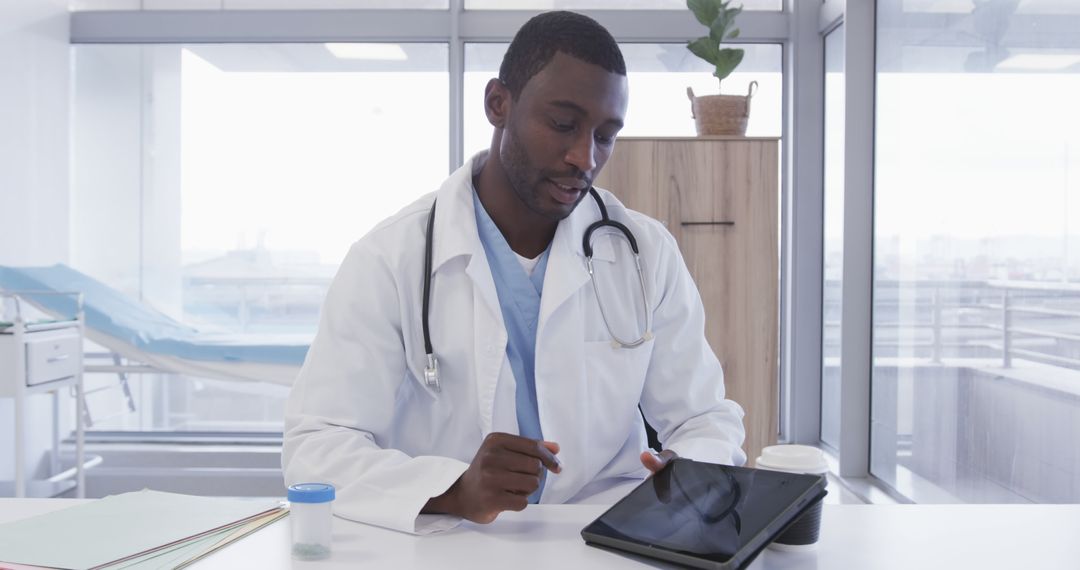 African American Male Doctor Using Tablet Computer in Bright Office - Free Images, Stock Photos and Pictures on Pikwizard.com