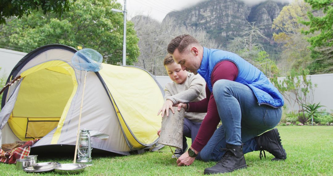 Father and son setting up camp in backyard with mountainous background - Free Images, Stock Photos and Pictures on Pikwizard.com