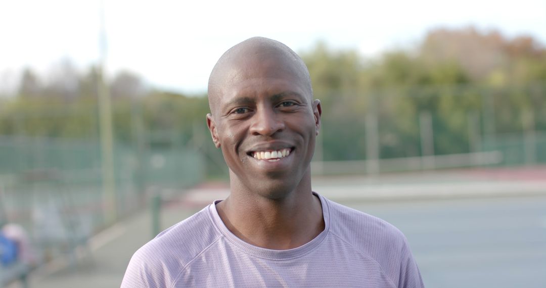 Portrait of happy african american male tennis player on sunny court - Free Images, Stock Photos and Pictures on Pikwizard.com