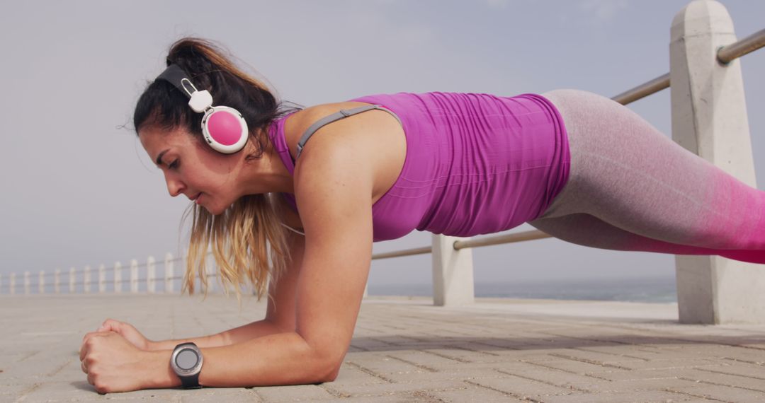 Fit Woman Doing Plank Exercise Outdoors Wearing Headphones - Free Images, Stock Photos and Pictures on Pikwizard.com