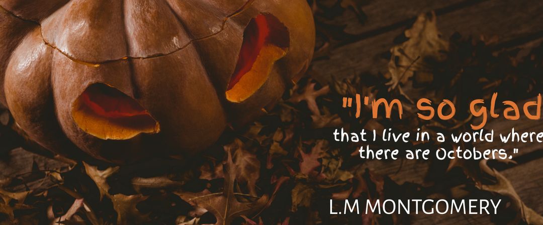 Carved Pumpkin Amidst Fallen Leaves with L.M. Montgomery Quote