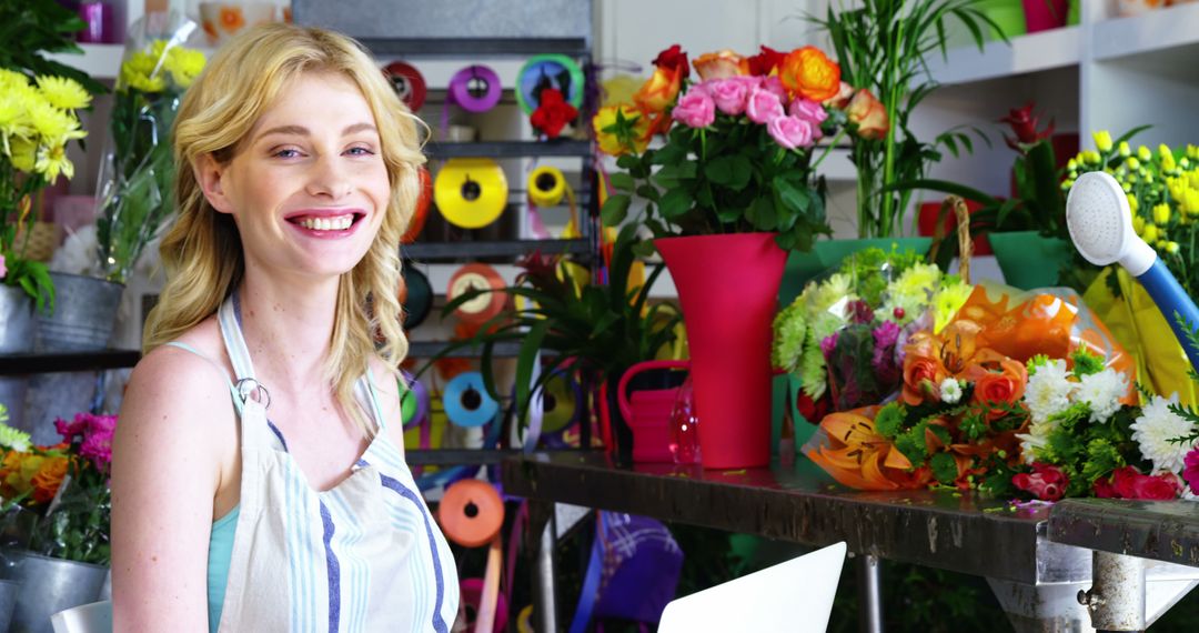 Cheerful Female Florist Using Laptop in Colorful Flower Shop - Free Images, Stock Photos and Pictures on Pikwizard.com