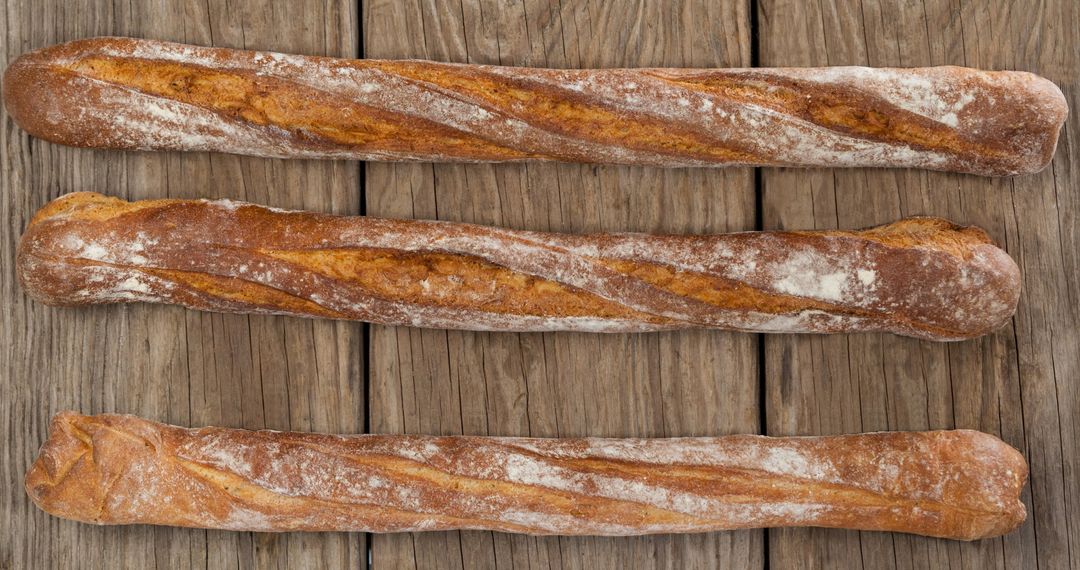 Three Fresh Baguettes Displayed on Rustic Wooden Table
