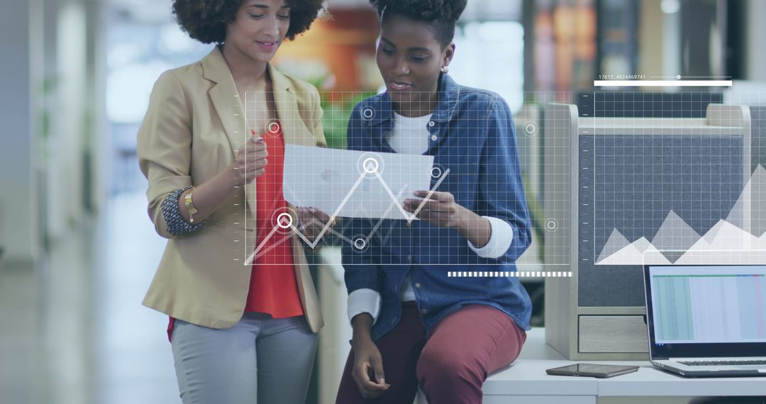 Businesswomen Analyzing Data in Modern Office Environment