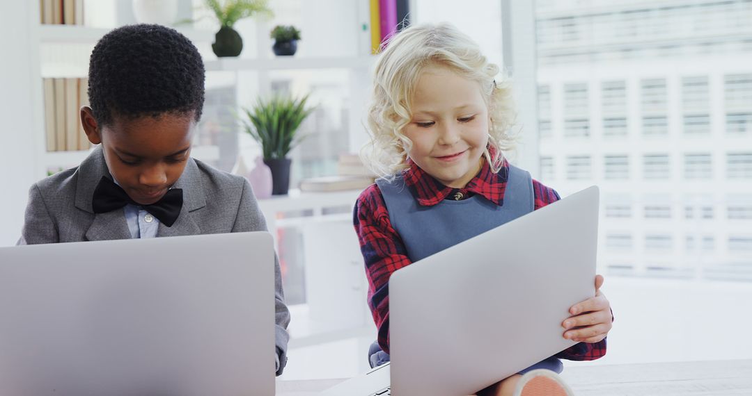 Two Diverse Children Using Laptops in Modern Classroom - Free Images, Stock Photos and Pictures on Pikwizard.com