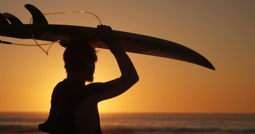 Surfer Carrying Surfboard at Sunset on Beach - Free Images, Stock Photos and Pictures on Pikwizard.com