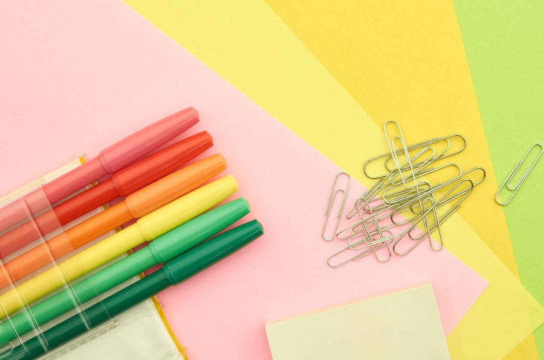 Colorful Pens and Paperclips on Multicolored Background