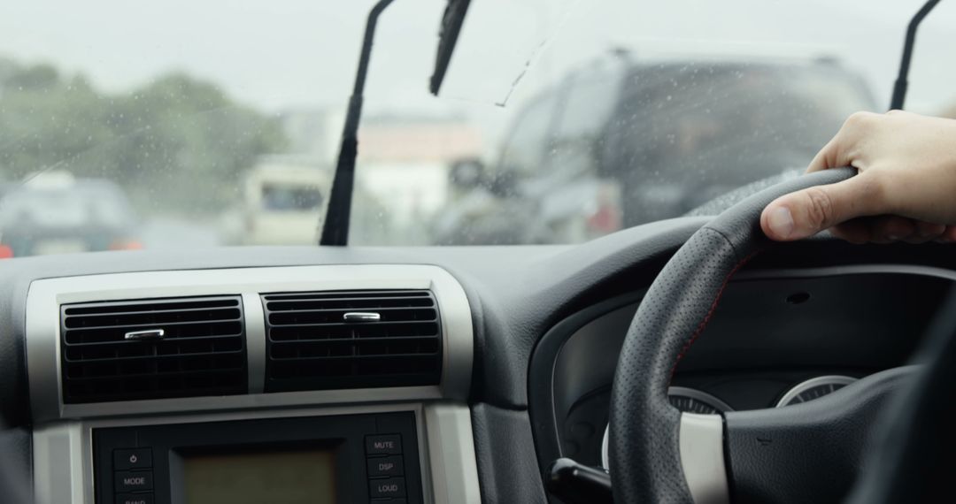 Close-Up of Driver's Hand on Steering Wheel During Rainy Traffic - Free Images, Stock Photos and Pictures on Pikwizard.com