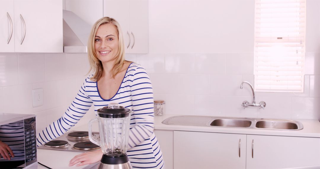 Woman Smiling while Preparing Food in Modern Kitchen - Free Images, Stock Photos and Pictures on Pikwizard.com