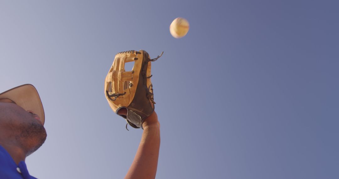 Baseball Player Catching Ball Under Clear Blue Sky - Free Images, Stock Photos and Pictures on Pikwizard.com