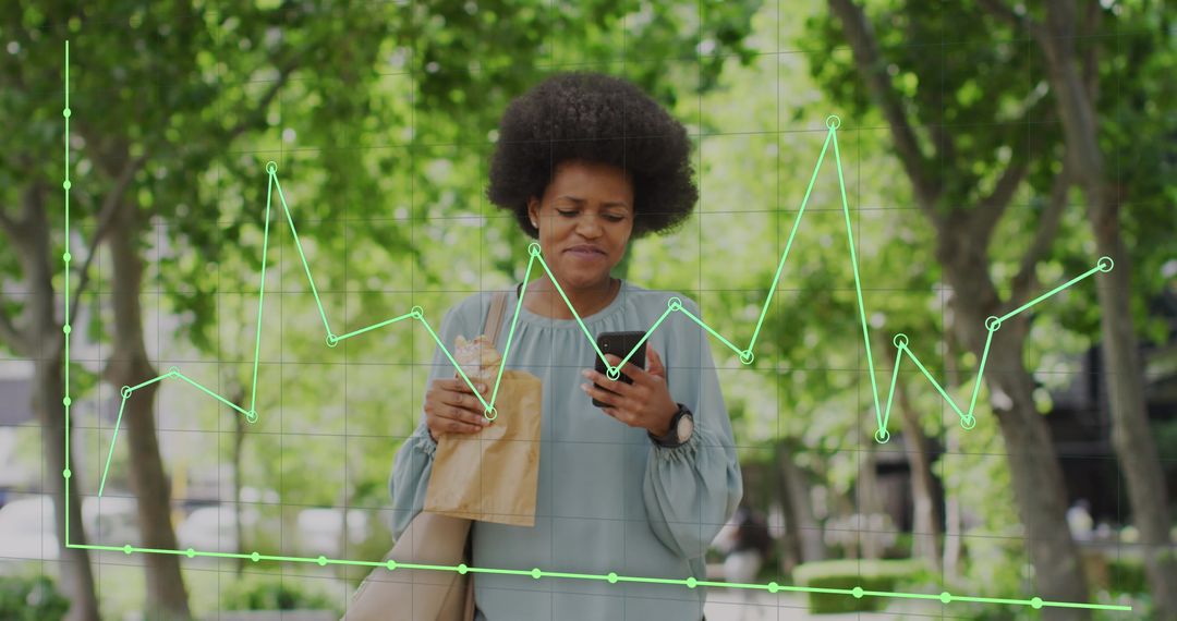 African American Woman Checking Smartphone with Overlaid Business Graphs