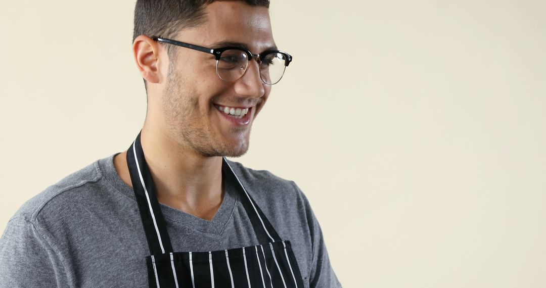 Smiling young chef wearing striped apron and glasses - Free Images, Stock Photos and Pictures on Pikwizard.com