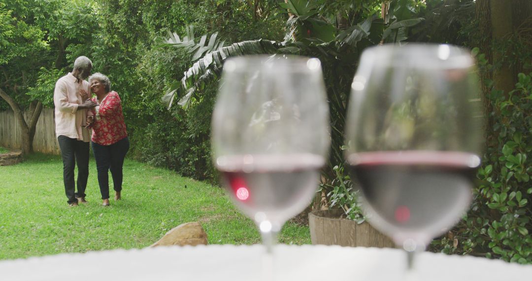 Elderly Couple Dancing in Garden with Wine Glasses in Foreground - Free Images, Stock Photos and Pictures on Pikwizard.com