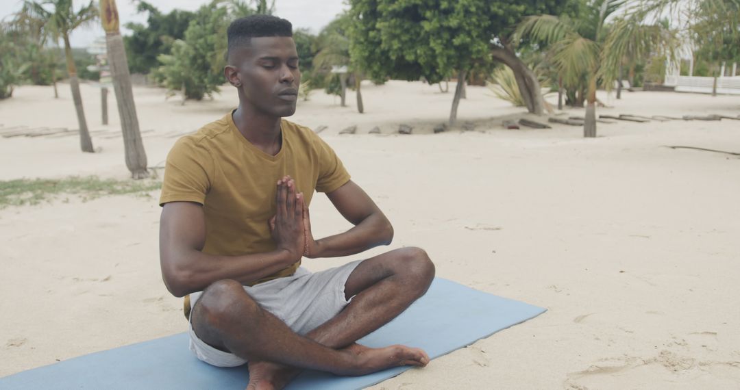 Man Meditating on Beach in Yoga Pose - Free Images, Stock Photos and Pictures on Pikwizard.com