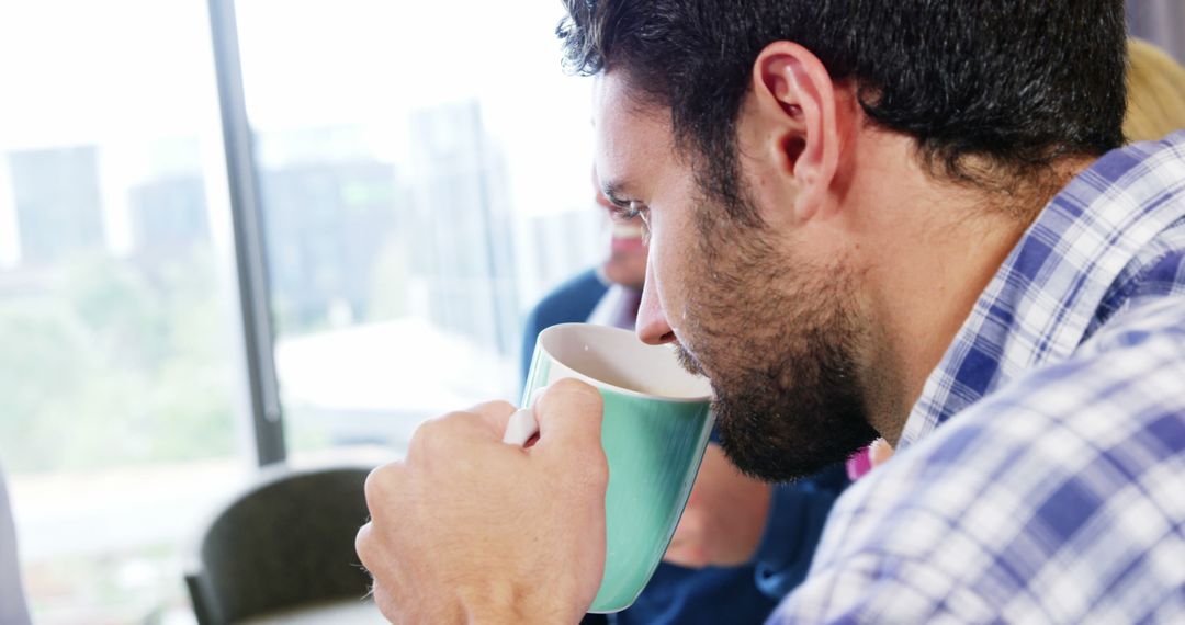 Man Drinking Coffee During Office Meeting - Free Images, Stock Photos and Pictures on Pikwizard.com