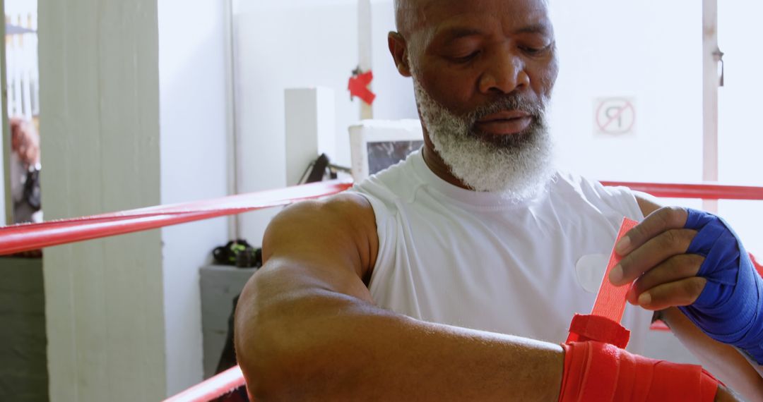 Senior Male Boxer Wrapping Hands Preparing for Training - Free Images, Stock Photos and Pictures on Pikwizard.com