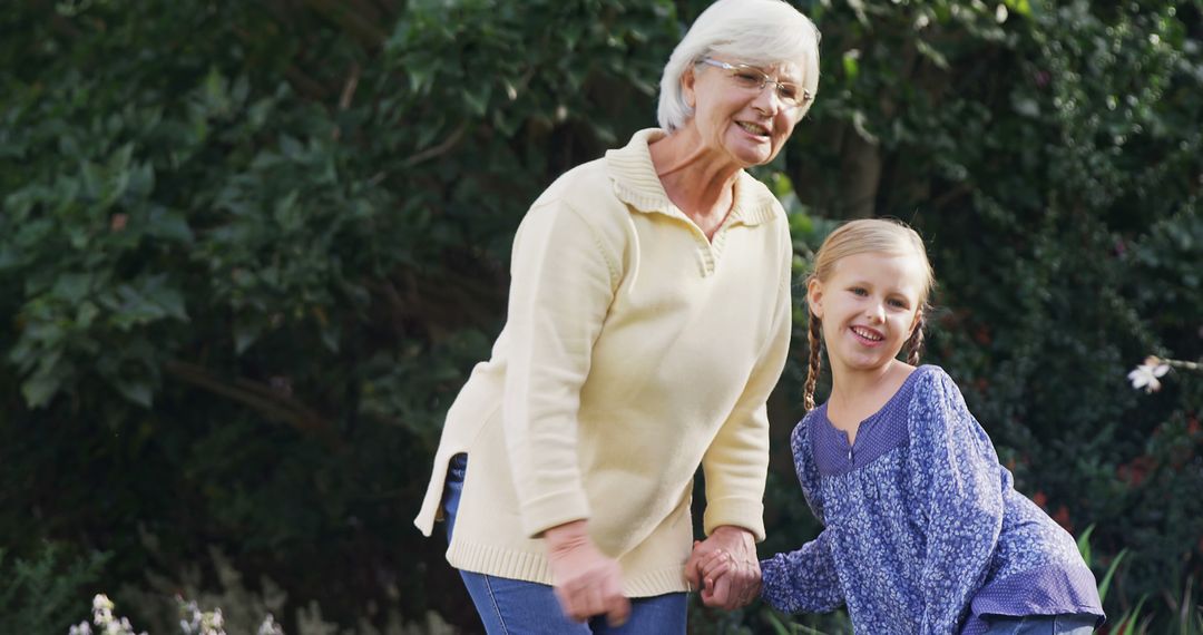 Grandmother Holding Hand of Smiling Granddaughter Outdoors - Free Images, Stock Photos and Pictures on Pikwizard.com