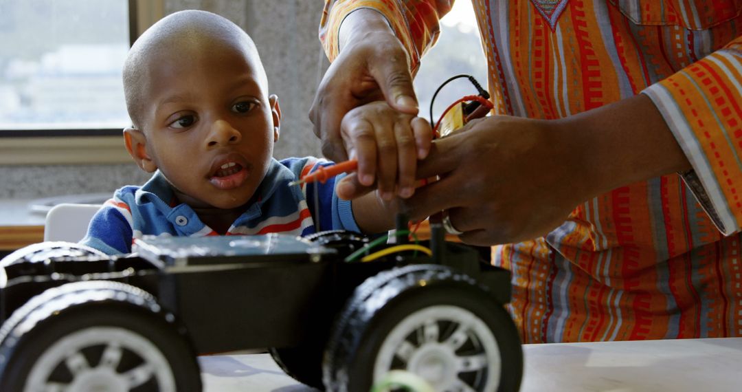 Father Teaching Son to Repair Remote-Control Car at Home