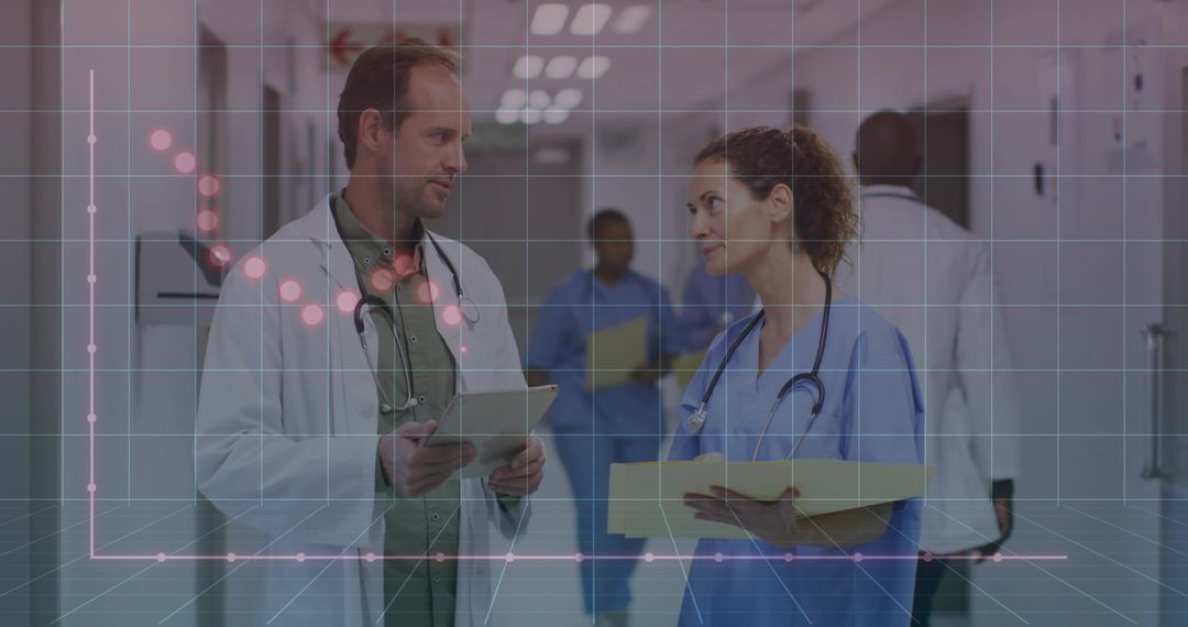 Medical staff discussing patient data in hospital corridor