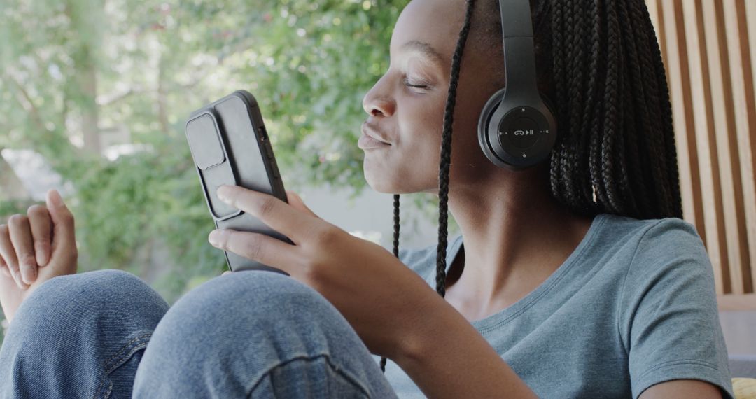 Teen Enjoying Music on Smartphone with Headphones in Cozy Home Environment - Free Images, Stock Photos and Pictures on Pikwizard.com