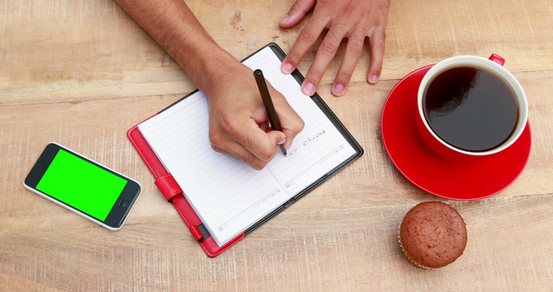 Person Writing Notes with Coffee and Muffin at Desk - Free Images, Stock Photos and Pictures on Pikwizard.com