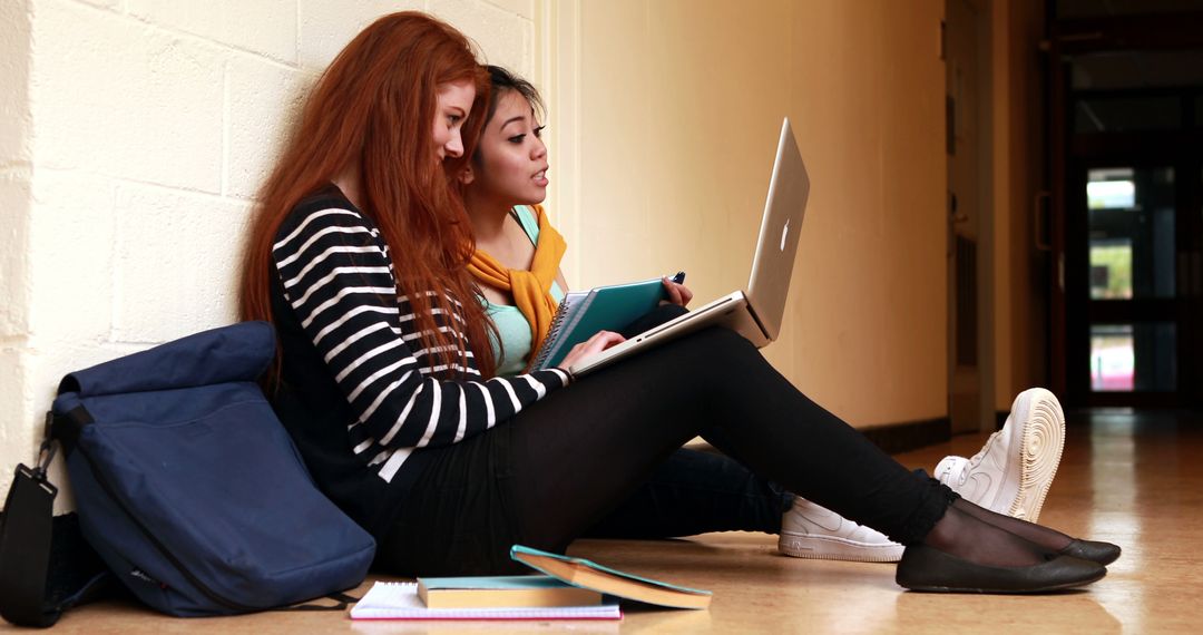 College Students Sitting in Hallway Using Laptop and Writing Notes - Free Images, Stock Photos and Pictures on Pikwizard.com