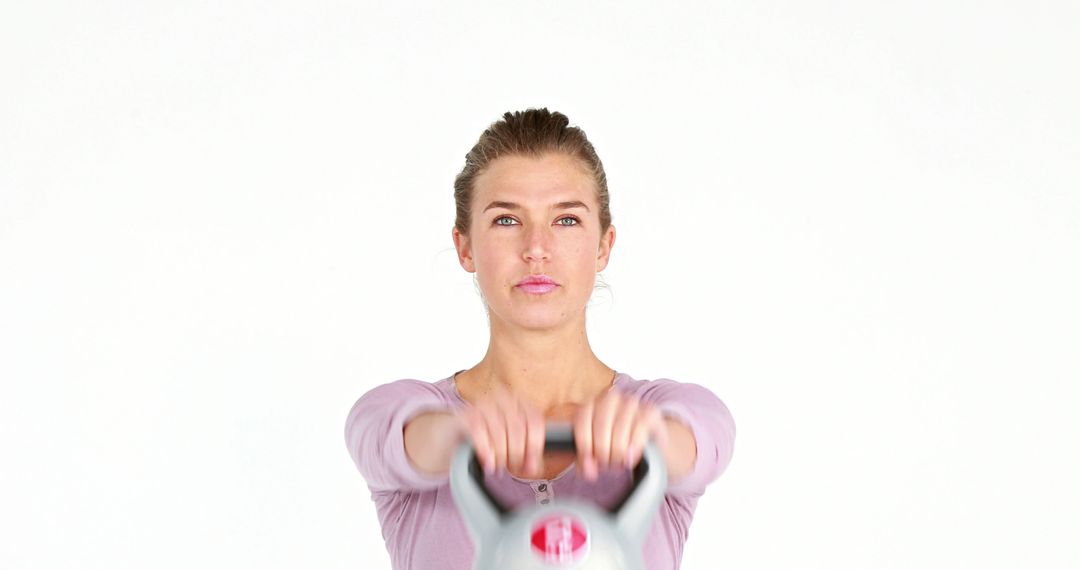 Focused Woman Exercising with Kettlebell in Studio - Free Images, Stock Photos and Pictures on Pikwizard.com