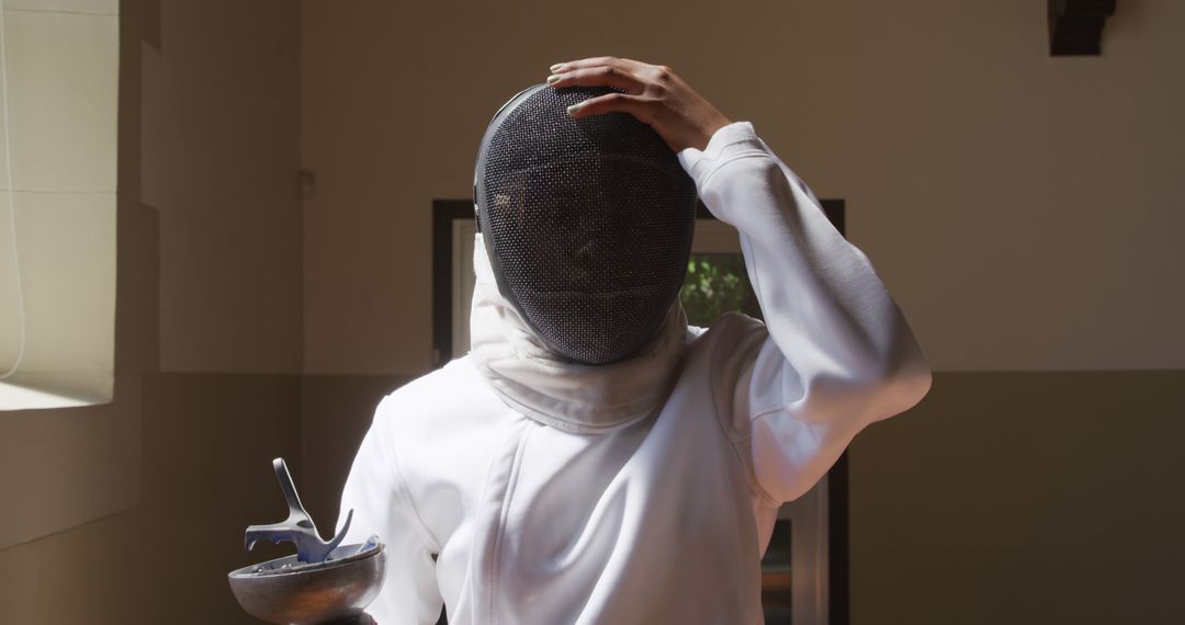 Fencer Adjusting Helmet During Training Session - Free Images, Stock Photos and Pictures on Pikwizard.com