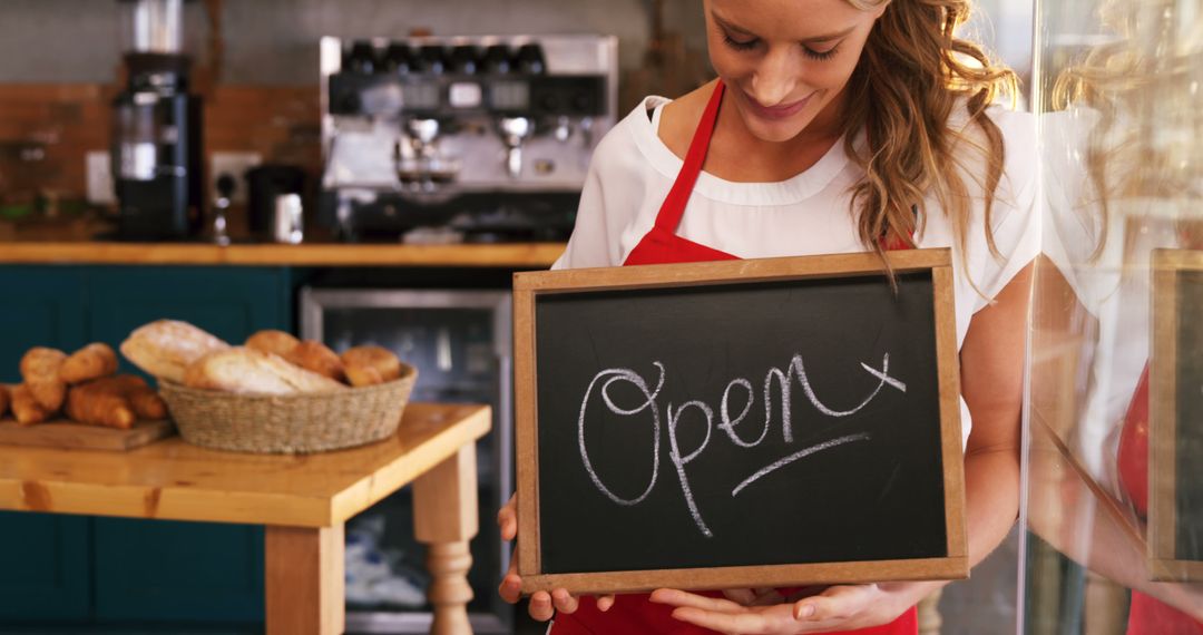 Smiling Female Barista Holding Open Sign in Cafe - Free Images, Stock Photos and Pictures on Pikwizard.com