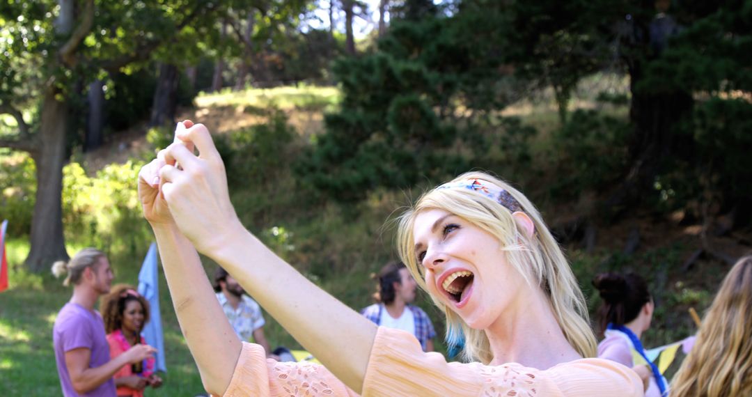 Young Woman Taking Selfie in Park During Outdoor Gathering - Free Images, Stock Photos and Pictures on Pikwizard.com