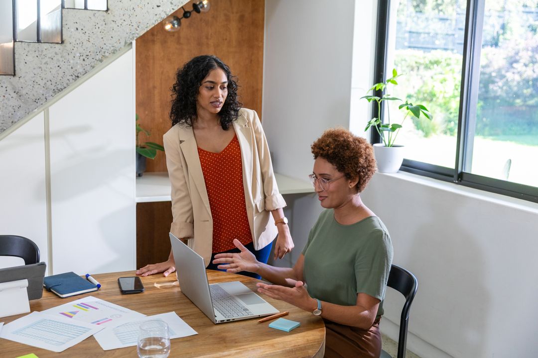 Female Colleagues Collaborating in Modern Office with Natural Light