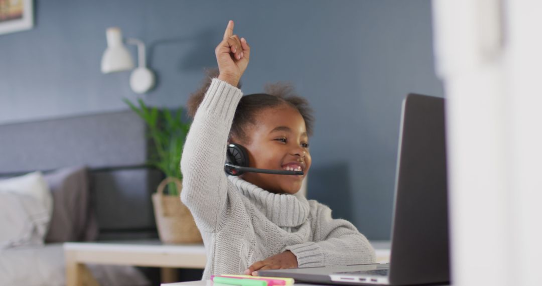 Smiling Child with Headset Raising Hand During Online Learning - Free Images, Stock Photos and Pictures on Pikwizard.com